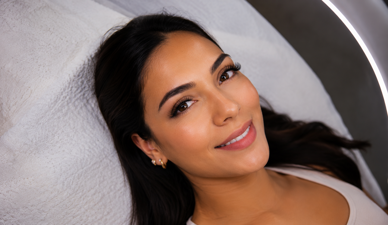 Clienta sonriendo con pestañas definidas y cejas perfectamente diseñadas